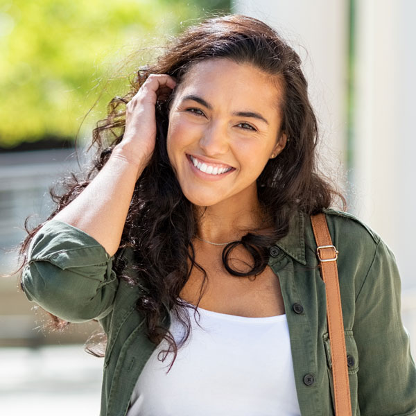 young woman in green jacket smiling