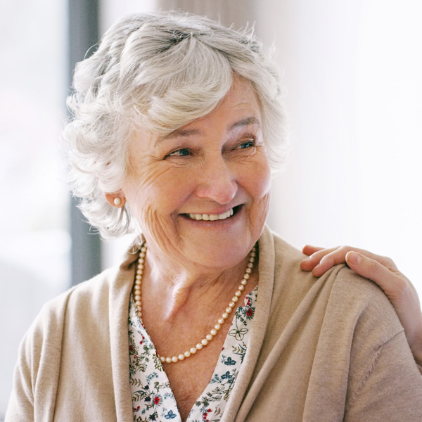 senior woman with pearl necklace smiling